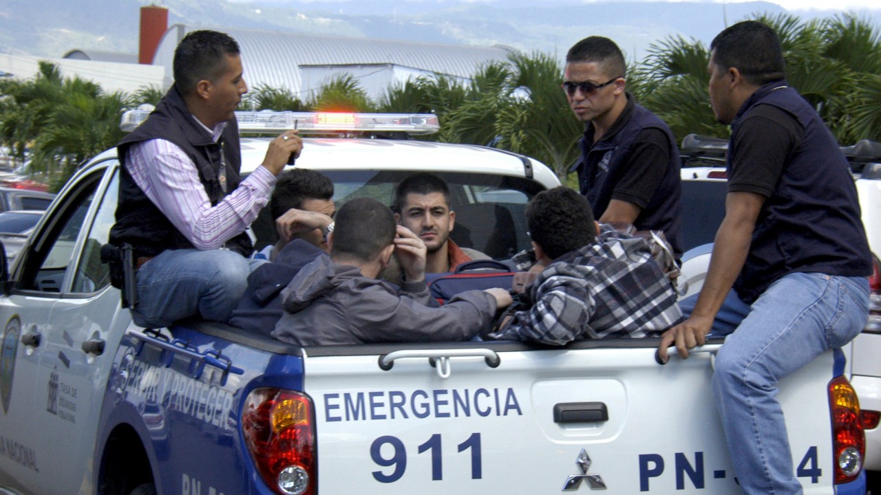Policiais escoltam cinco homens sírios detidos no aeroporto internacional de Toncontin em Tegucigalpa, Honduras - 18/11/2015