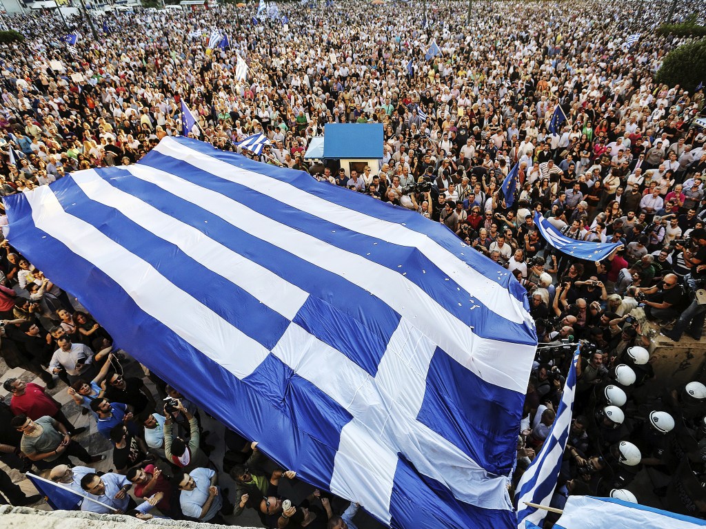 Manifestantes carregam uma bandeira grega durante um comício em frente ao edifício do parlamento em Atenas pedindo ao governo para fechar um acordo com seus credores internacionais e garantir o futuro da Grécia na zona do euro - 22/06/2015