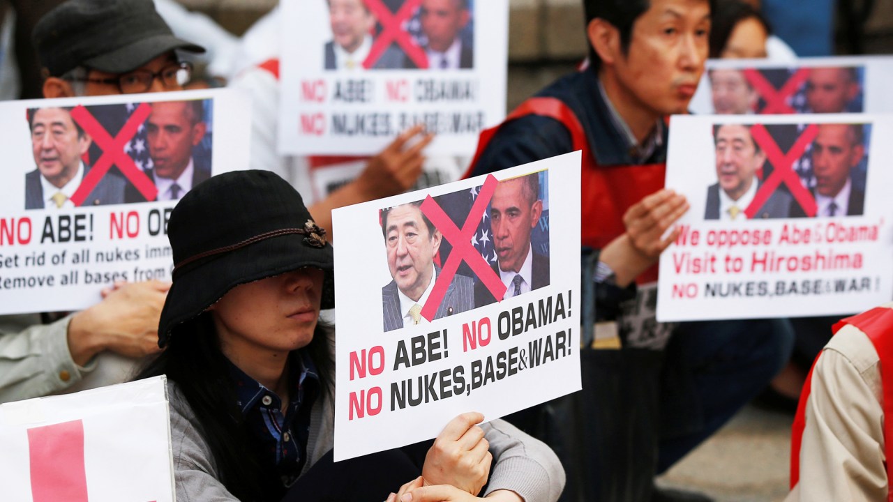 Japoneses seguram cartazes para protestar contra o presidente dos Estados Unidos, Barack Obama, no Parque Memorial da Paz, em Hiroshima, no Japão - 26/05/2016