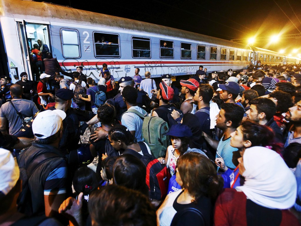 Dezenas de imigrantes tentam embarcar em um trem na estação de Tovarnik, Croácia - 17/09/2015