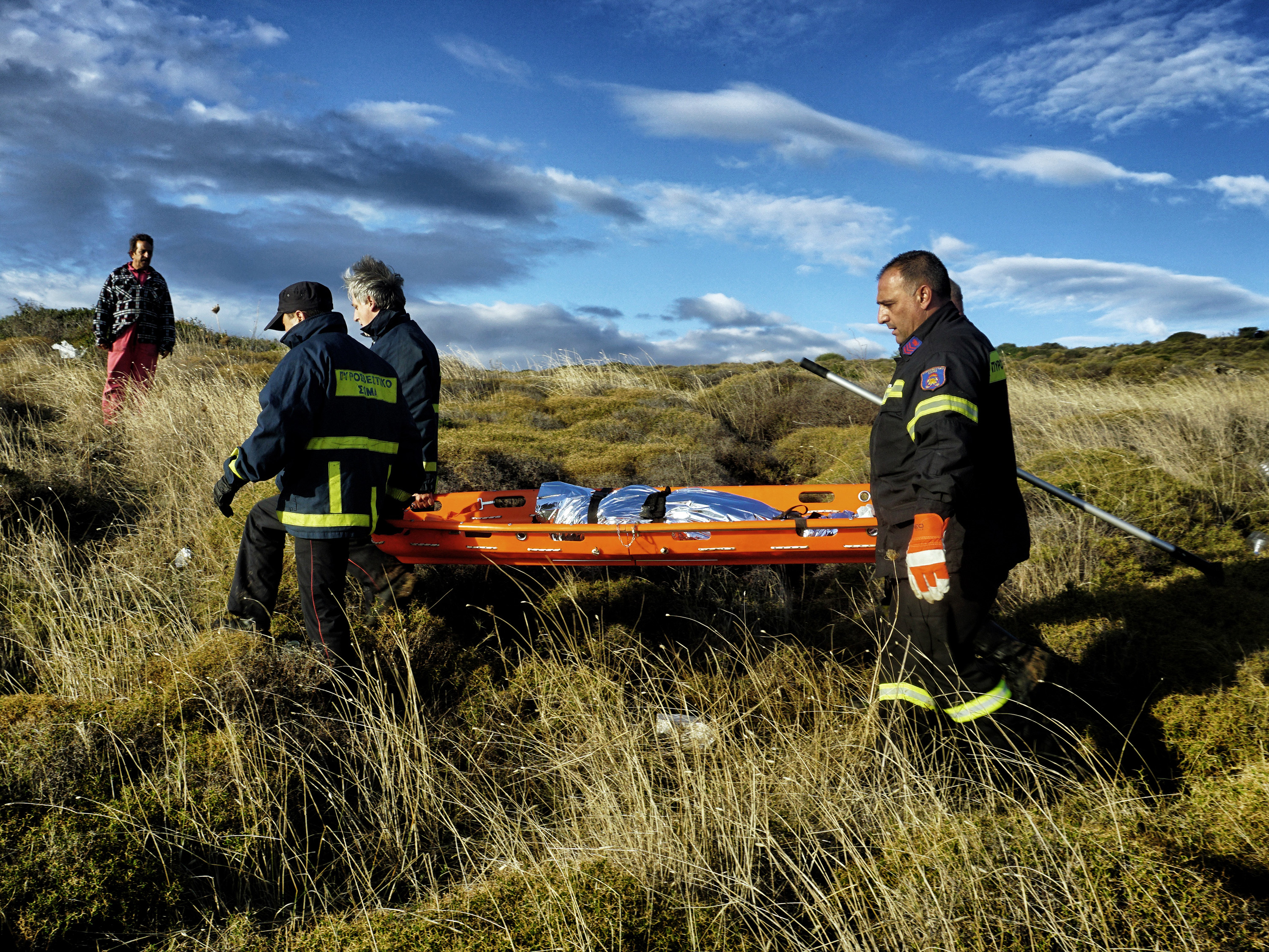Bombeiros carregam o corpo de uma criança após acidente com um bote de refugiados vindo da Turquia na ilha grega de Lesbos - 25/10/2015