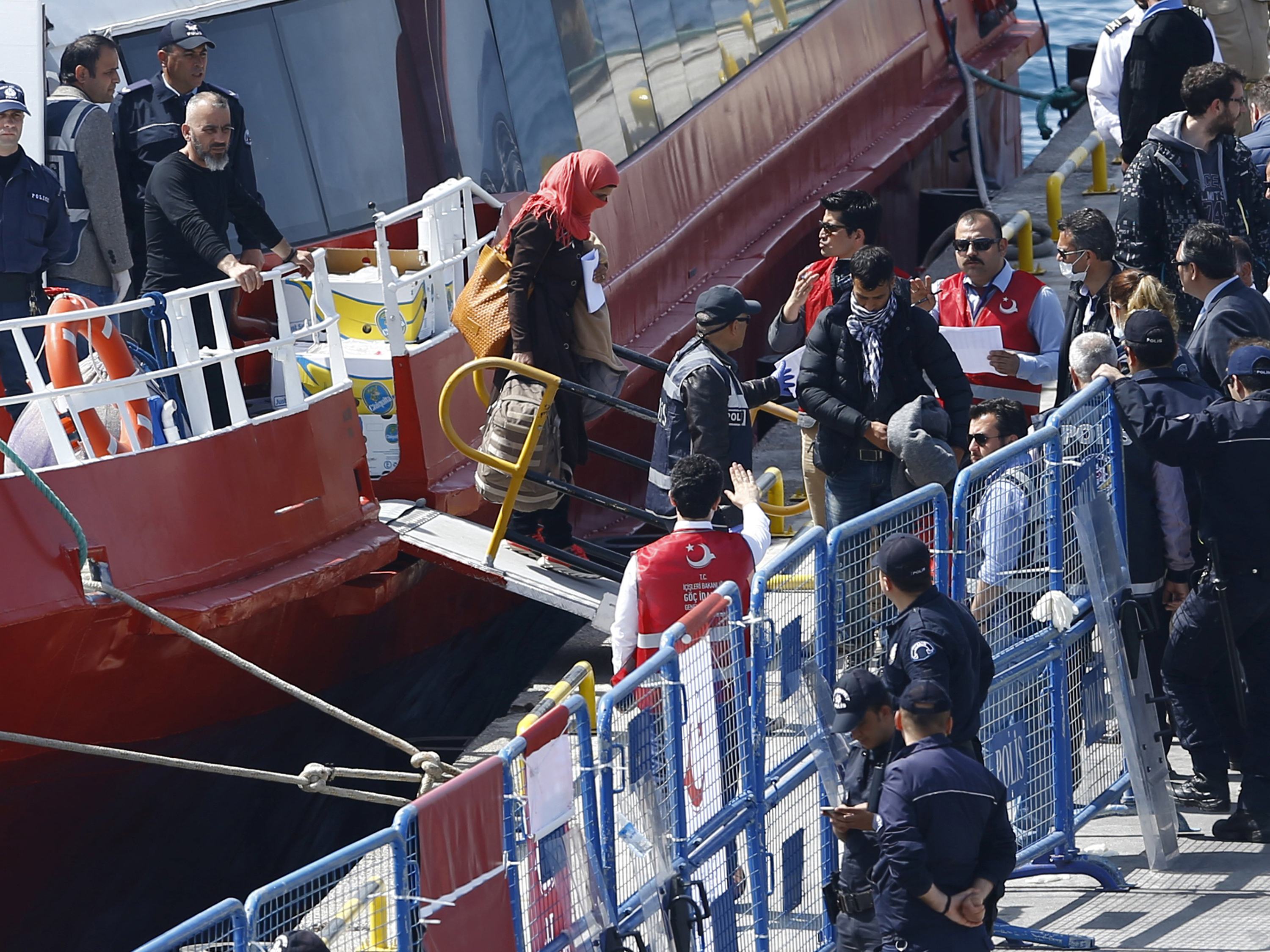 Refugiados são escoltados por policiais enquanto chegam à cidade costeira de Dikili, na Turquia - 04/04/2016