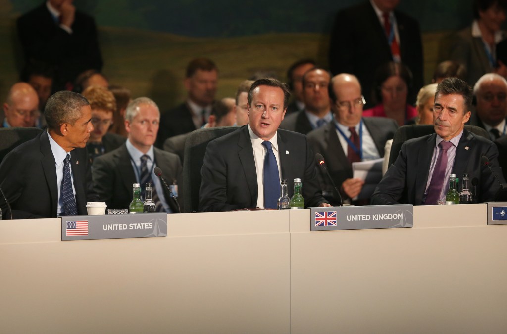 O presidente dos Estados Unidos, Barack Obama (esq.) e o secretário-geral da Otan, Anders Fogh Rasmussen (dir.) ouvem o discurso do primeiro-ministro britânico David Cameron durante a reunião de cúpula da Otan em Newport, no País de Gales