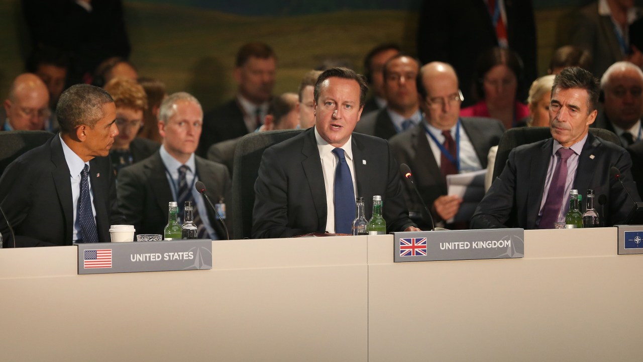 O presidente dos Estados Unidos, Barack Obama (esq.) e o secretário-geral da Otan, Anders Fogh Rasmussen (dir.) ouvem o discurso do primeiro-ministro britânico David Cameron durante a reunião de cúpula da Otan em Newport, no País de Gales