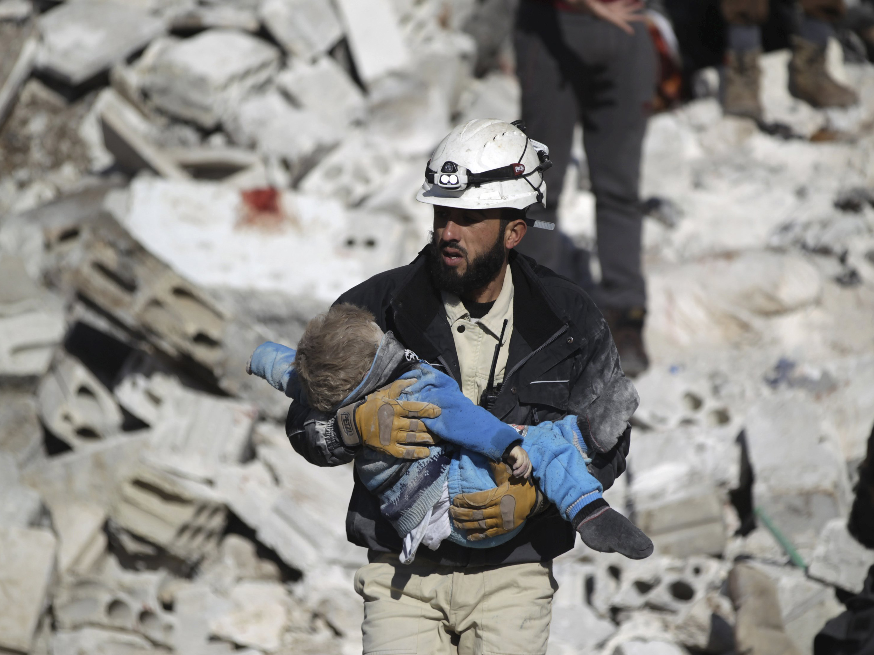 Membro da defesa civil carrega uma criança morta em um local atingido por ataques aéreos realizados pela Rússia em uma região controlada por rebeldes em Maaret al-Numan, província de Idlib, na Síria - 09/01/2016