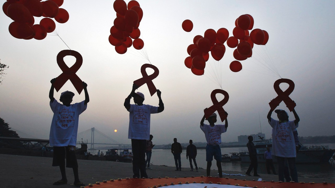 Crianças soltam balões com mensagens de uma campanha de conscientização sobre o HIV/AIDS em Calcutá, na India. Dados publicados nesta terça revelam que 15 milhões de pessoas estão recebendo os coquetéis de combate ao vírus