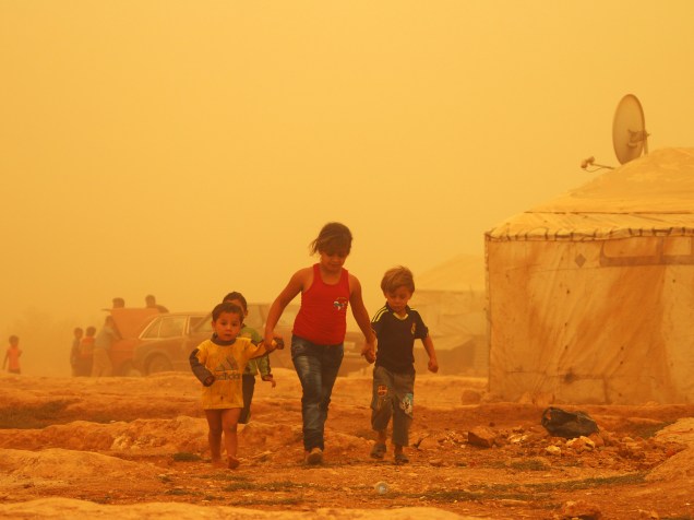 Crianças sírias caminham em meio a uma tempestade de areia em um campo de refugiados nos arredores da cidade libanesa de Baalbek - 07/09/2015
