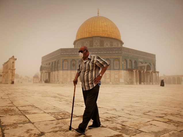 Homem caminha em frente ao Domo da Rocha, em Jerusalém, usando uma máscara para se proteger da tempestade de areia - 08/09/2015