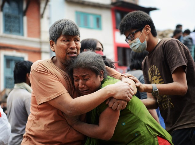 Familiares se abraçam na Praça Durbar em Katmandu, Patrimônio Mundial da Unesco, que foi severamente danificada pelo terremoto