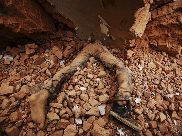 Corpo de uma vítima fica preso nos escombros após o terremoto, em Katmandu, Nepal - 25/04/2015
