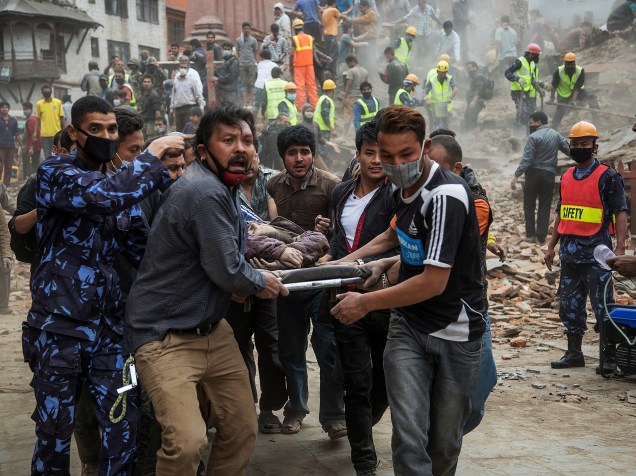 Equipes de resgate carregam uma vítima após o desabamento da torre Dharara, em Katmandu, Nepal - 25/04/2015