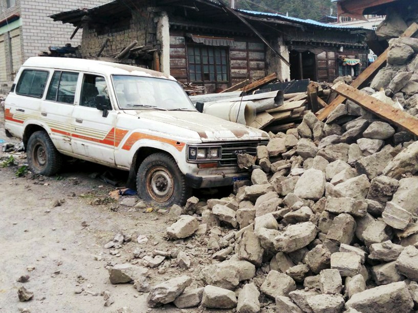 Carro junto aos escombros de uma casa, após o terremoto de magnitude 7,8 que atingiu o Nepal, próximo à prefeitura de Xigaze, na região autônoma do Tibet, China - 25/04/2015