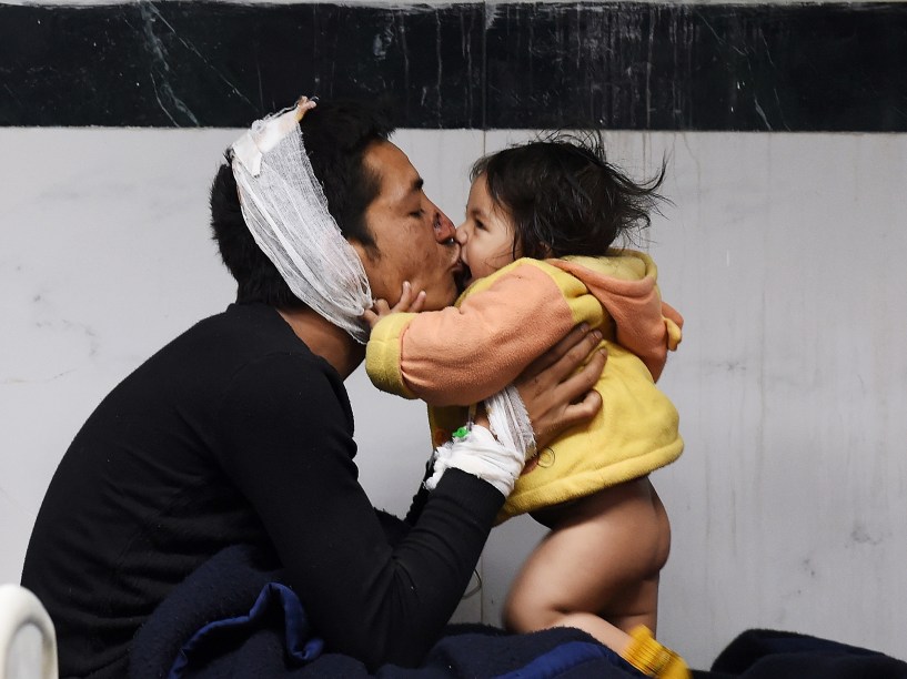 Homem ferido brinca com sua filha em um hospital de Katmandu, Nepal - 26/04/2015