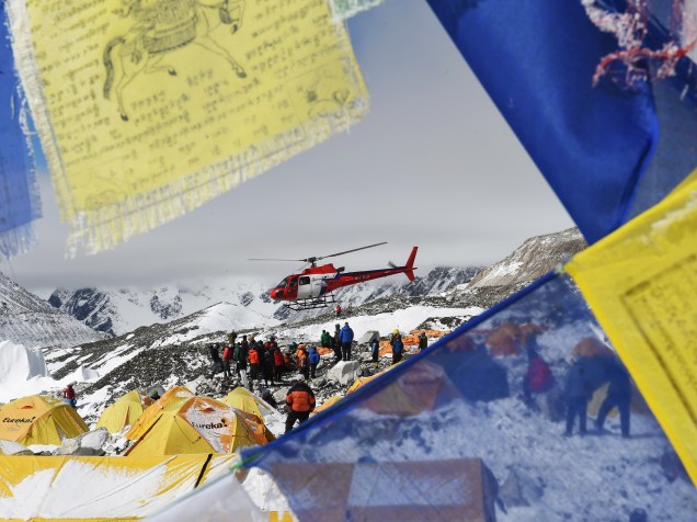 Bandeiras com orações são vistas enquanto um helicóptero resgata as vítimas da avalance no acampamento-base do Monte Everest - 26/04/2015