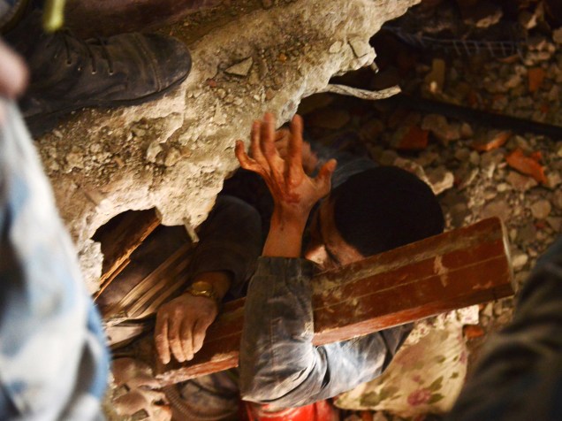 Equipe de resgate tenta retirar um sobrevivente debaixo dos escombros de uma casa um dia depois do terremoto em Katmandu, Nepal - 26/04/2015