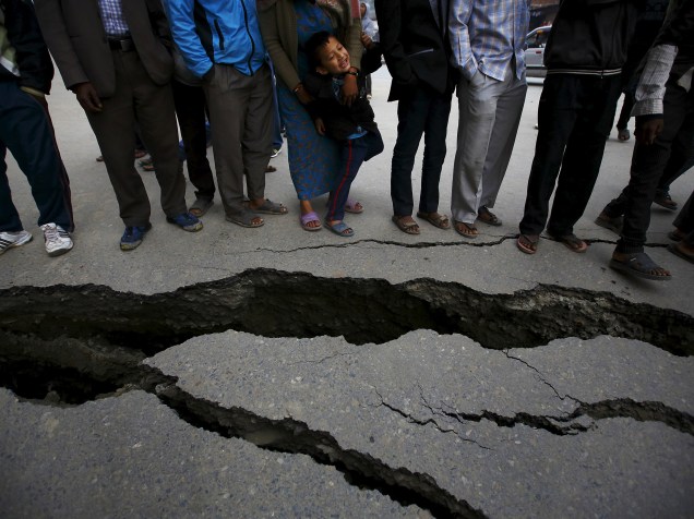 Pessoas se reúnem perto das rachaduras em uma estrada causadas pelo terremoto em Bhaktapur, Nepal - 26/04/2015