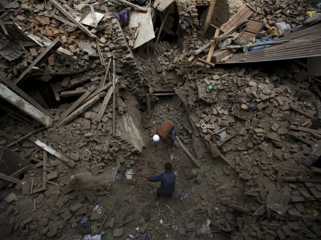 Pessoas buscam por familiares entre os escombros das casas que desabaram com o terremoto em Bhaktapur, Nepal - 26/04/2015