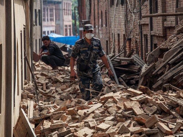 Policiais caminha em uma rua coberta de escombros em Bhaktapur, Nepal - 26/04/2015