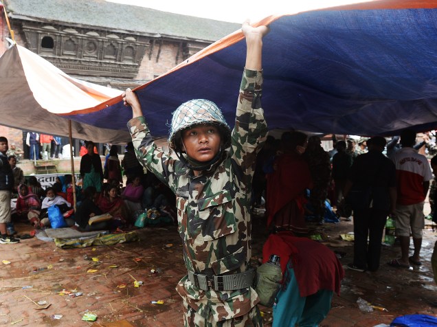 Integrante das forças de segurança do Nepal monta uma tenda para atender feridos em Bhaktapur - 26/04/2015