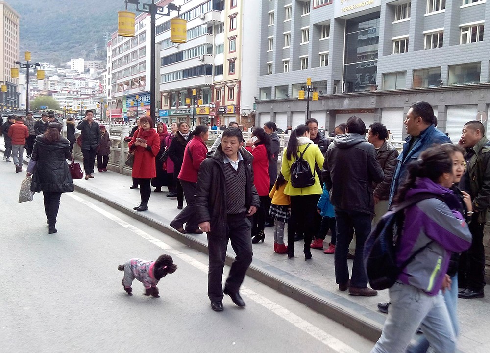 Moradores ficam do lado de fora dos edifícios após um terremoto atingir a província de Sichuan, sudoeste da China, neste sábado (22)