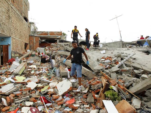  Policiais andam sobre os escombros de um prédio, na cidade de Manta, no Equador, após forte terremoto atingir o país - 17/04/2016