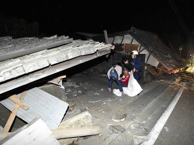Moradores são retirados de suas casas por equipes de resgate após terremoto atingir a cidade de Kumamoto, sudoeste do Japão - 14/04/2016