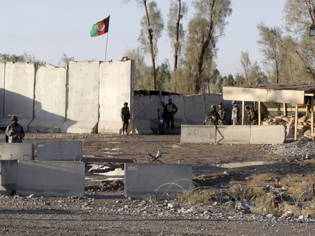Forças de segurança afegãs ficam de guarda no portão de entrada do aeroporto de Kandahar, o local foi alvo de um ataque de insurgentes do Talibã - 09/12/2015