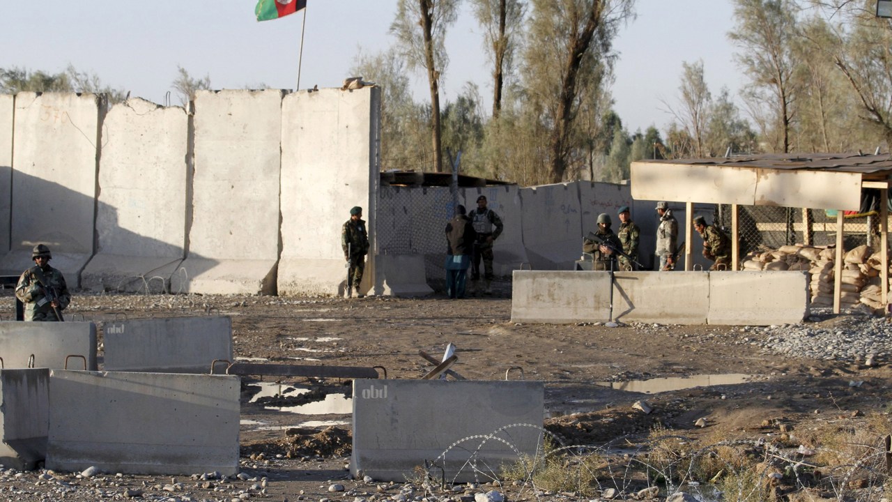 Forças de segurança afegãs ficam de guarda no portão de entrada do aeroporto de Kandahar, o local foi alvo de um ataque de insurgentes do Talibã - 09/12/2015