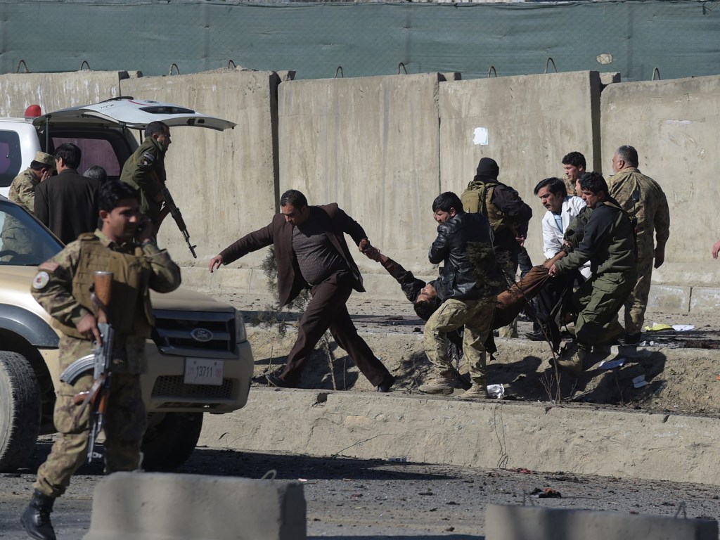 Forças de segurança afegãs carregam uma vítima no local de um atentado com um carro-bomba próximo a uma base da polícia em Cabul - 01/02/2016