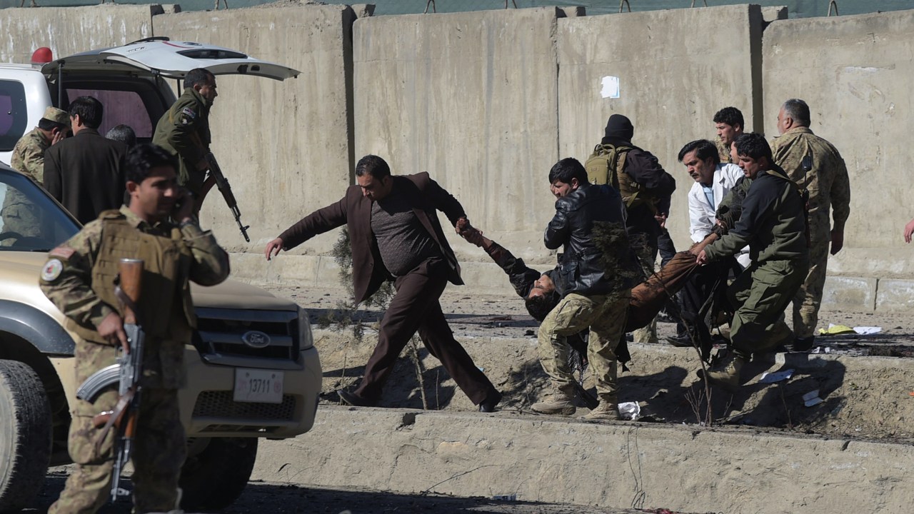 Forças de segurança afegãs carregam uma vítima no local de um atentado com um carro-bomba próximo a uma base da polícia em Cabul - 01/02/2016