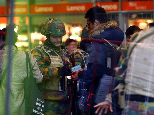 Soldado checa identificação de homem, em estação de trem de Bruxelas, na Bélgica, nesta quarta-feira (23), um dia depois dos atentados comandados pelo Estado Islâmico, deixarem dezenas de mortos