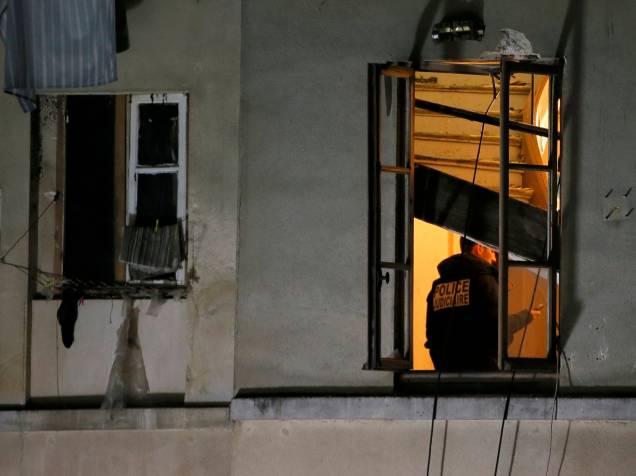 Membro da polícia judiciária francesa inspeciona o apartamento invadido pelas forças especiais em Saint-Denis, durante operação para capturar fugitivos dos ataques da última sexta-feira (13) - 18/11/2015