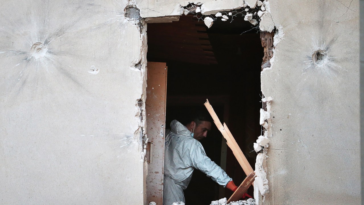Investigador forense inspeciona o apartamento invadido por forças especiais da polícia francesa durante operação antiterrorismo em Saint-Denis, norte de Paris - 18/11/2015