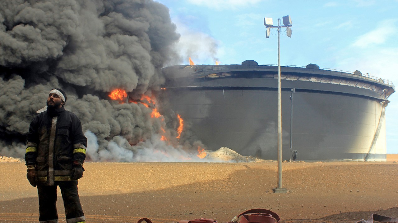 Bombeiros trabalham para extinguir um incêndio provocado por jihadistas do Estado Islâmico em uma instalação petrolífera na cidade de Ras Lanuf, norte da Líbia - 23/01/2016