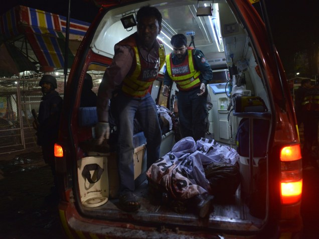 Equipes de resgate paquistanesas transportam um corpo para uma ambulância próxima ao local de um atentado a bomba em Lahore durante uma celebração que reunia cristãos no Domingo de Páscoa - 27/03/2016