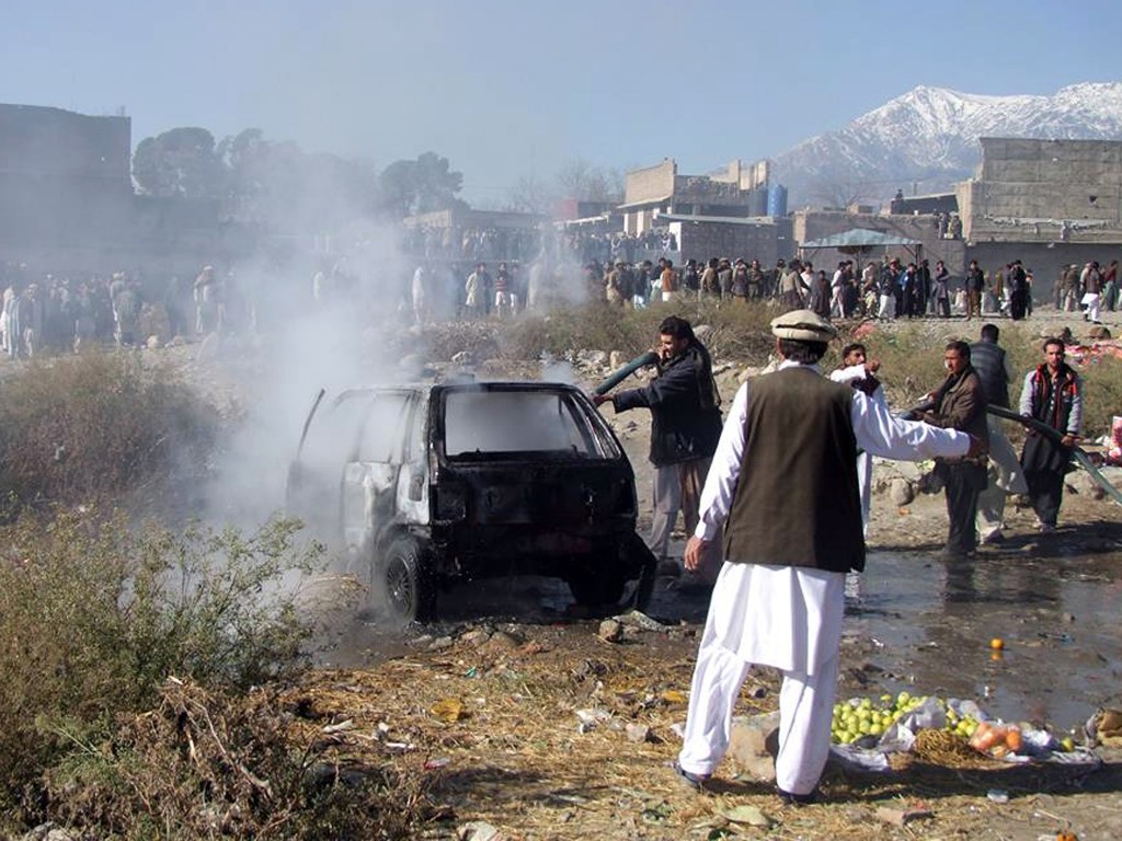 Bombeiros tentam extinguir um incêndio no local da explosão de uma bomba em um mercado em Parachinar, capital do distrito tribal Kurram, no Paquistão - 13/12/2015