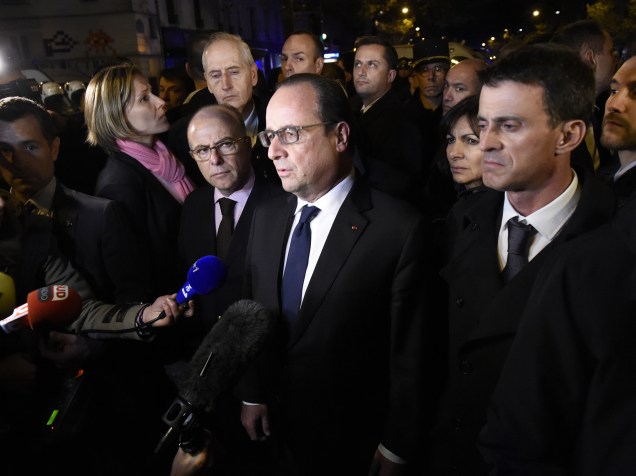 O presidente francês, François Hollande é abordado por jornalistas perto da sala de concertos Bataclan no centro de Paris - 13/11/2015