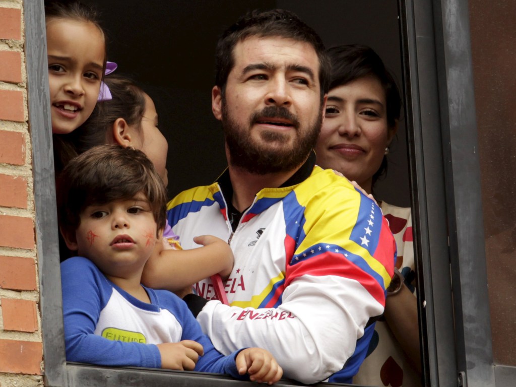 O ex-prefeito de San Cristóbal e opositor do governo venezuelano, Daniel Ceballos, aparece na janela de sua casa em Caracas ao lado dos filhos e da esposa Patricia Ceballos, após ter prisão domiciliar concedida por motivos de saúde - 12/08/2015
