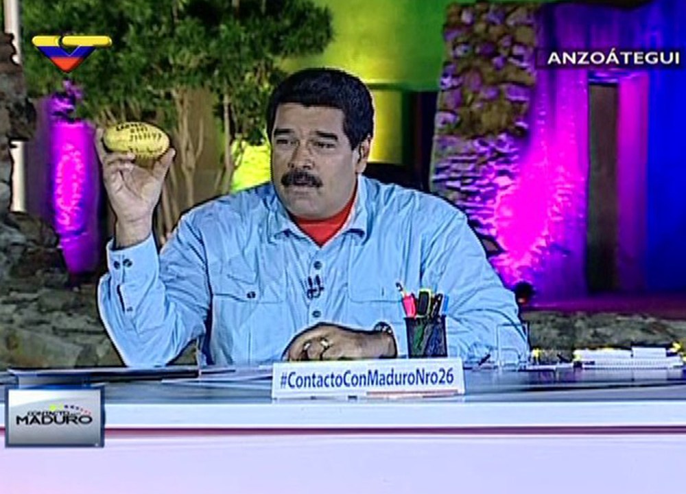 O presidente da Venezuela, Nicolás Maduro segura a manga atirada em sua cabeça durante programa da televisão do governo