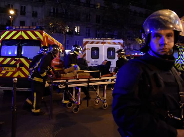 Equipe de resgate retira um homem ferido, nos arredores da sala de concertos Bataclan no centro de Paris - 13/11/2015