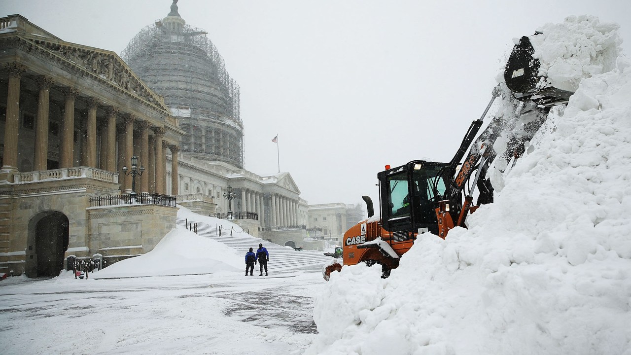 Funcionário usa uma escavadeira para remover neve próximo do Capitólio dos EUA, em Washington