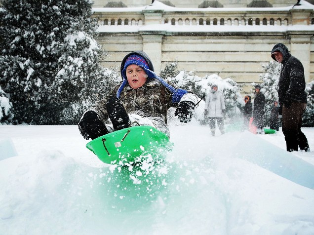 Criança brinca na neve em área perto do Capitólio, em Washington