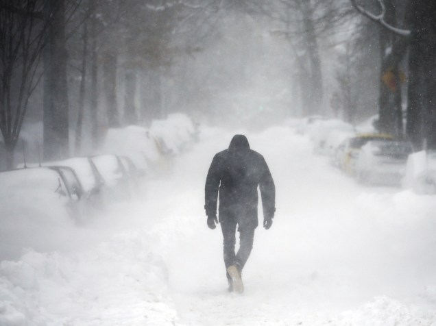 Um homem caminha ao longo de uma rua coberta pela neve durante uma tempestade de inverno em Washington<br>