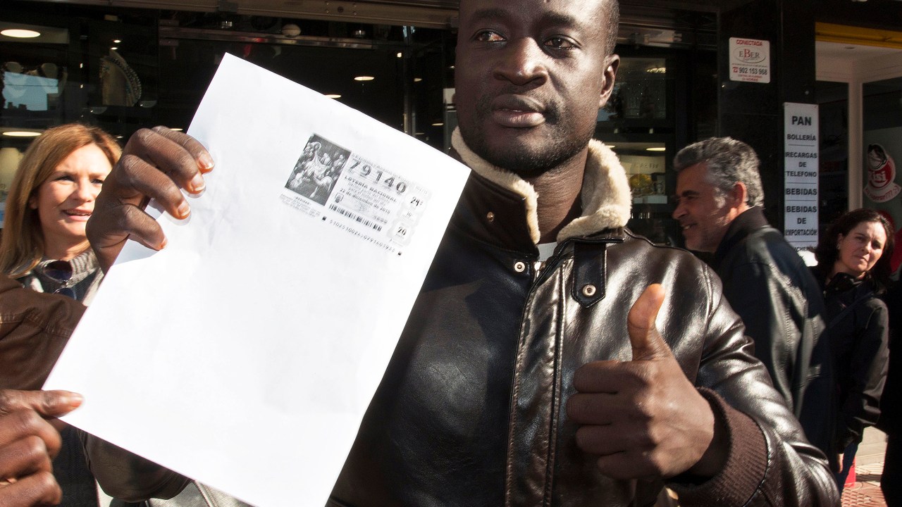 O senegalês Ngmae mostra cópia de seu bilhete premiado, em Roquetas de Mar, na Espanha