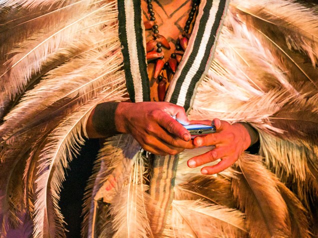 Índio usa o celular enquanto acompanha os Jogos Mundiais dos Povos Indígenas, em Palmas, Tocantins