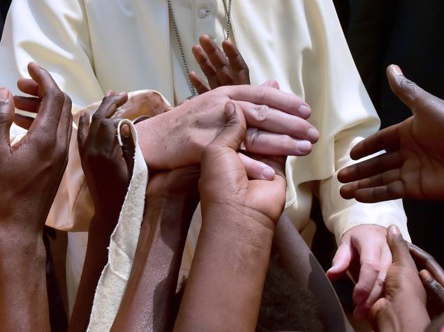 Crianças tocam a mão do papa Francisco em sua visita a um campo de refugiados em Bangui, na República Centro-Africana