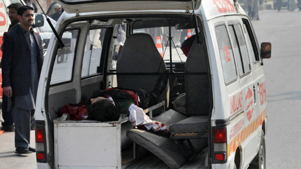 Uma ambulância transporta uma criança ferida em atendado contra uma escola no Paquistão