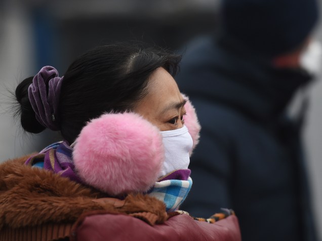 <p>Mulher usando máscara é fotografada durante um dia de forte poluição em Pequim, na China - 14/12/2015</p>