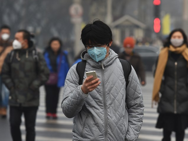 <p>Jovem usa máscara para se proteger da poluição em Pequim, nesta segunda-feira (14)</p>