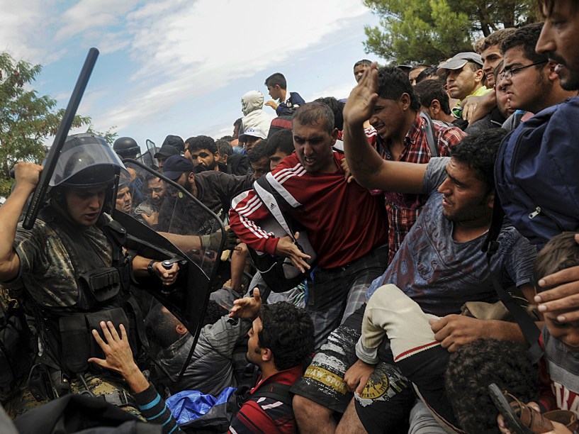 Policial macedônio tenta impedir imigrantes de atravessarem a fronteira entre Grécia e Macedônia. Foto vencedora do prêmio Pulitzer, o maior do fotojornalismo mundial - 22/08/2015